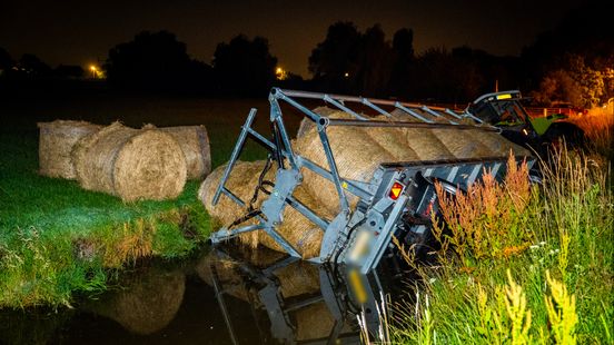 Aanhanger met hooibalen de sloot in