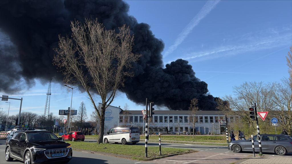 Grote rookwolk boven Amsterdam door brandende scooters