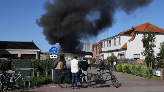 Zwarte rookwolken boven woonwijk na brand bij bedrijf