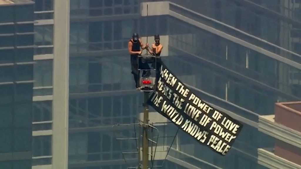 Stel beklimt naald van het Empire State met vredesspandoek, waarna ze zich verloven