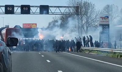 Gemaskerde hooligans lopen met fakkels over A4, spelersbus Ajax beschadigd: ‘Dit kan niet’